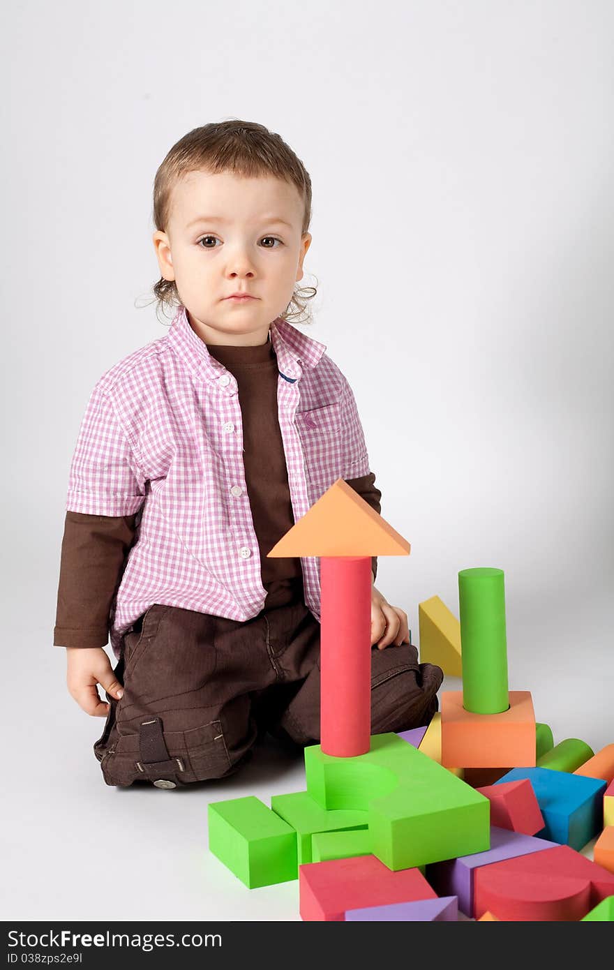 Little cute boy plays with cubes