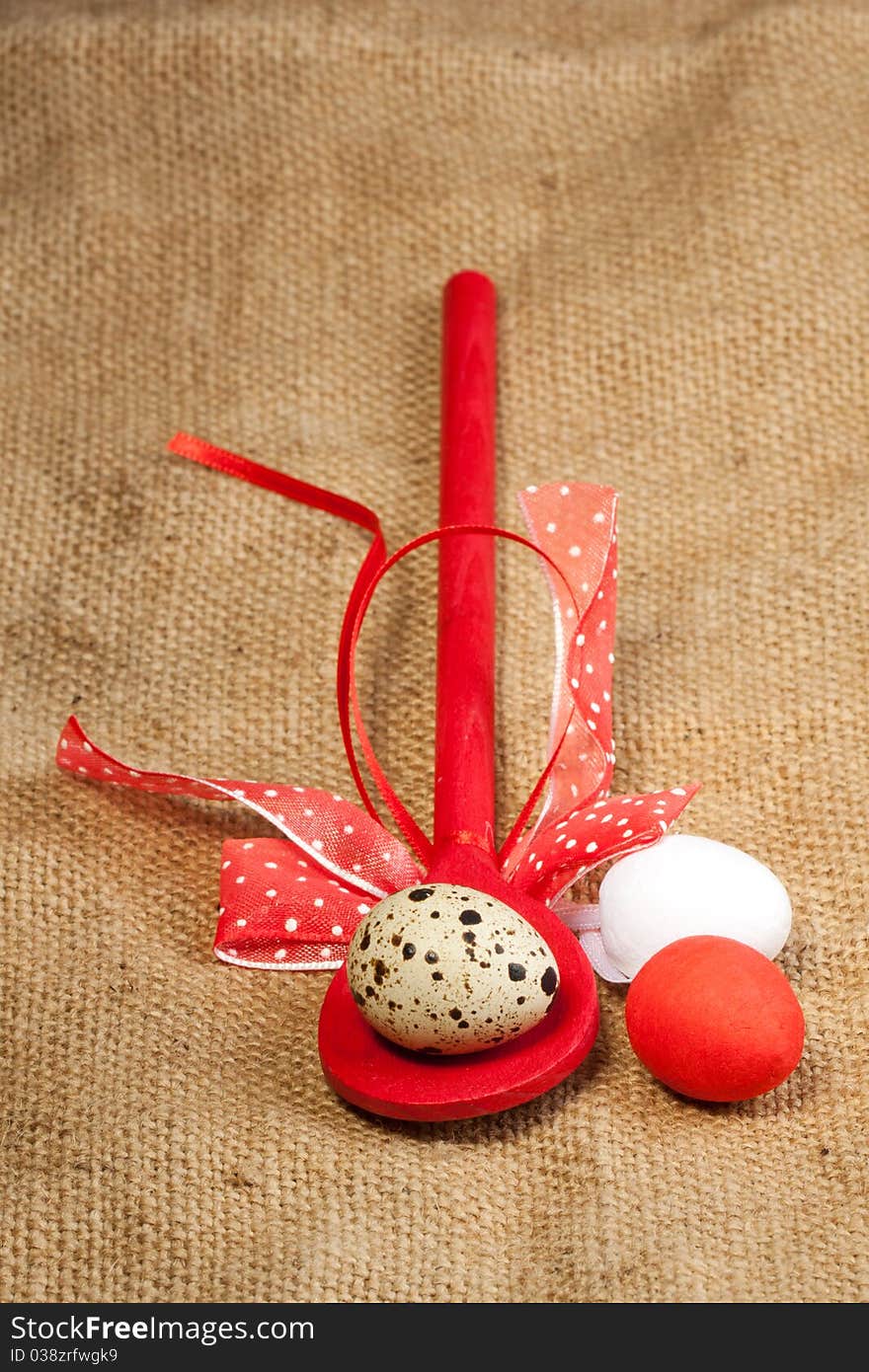 Easter eggs with red wooden spoon on sacking