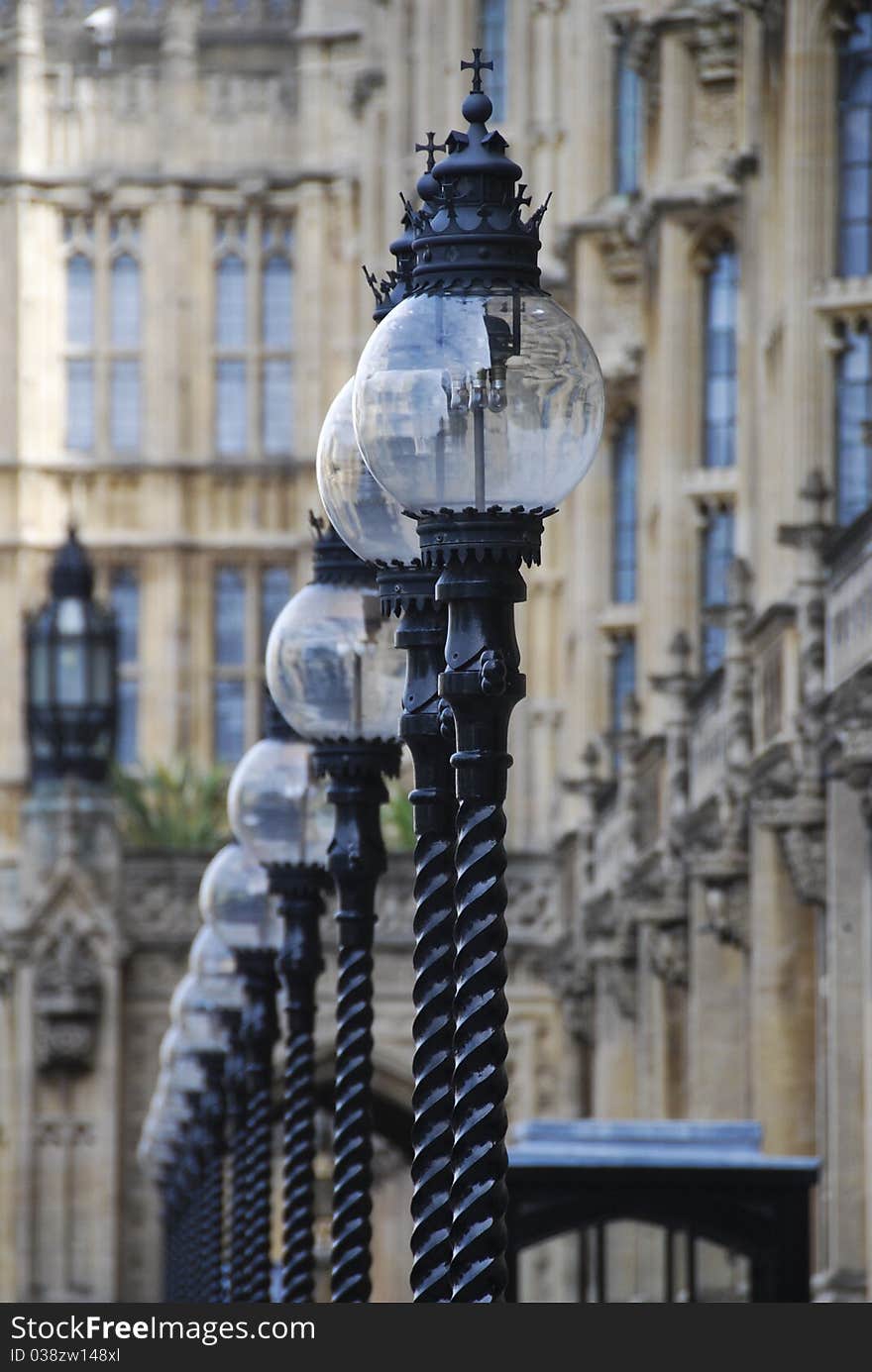 Decorative iron lamps stand in a row in front of Parliament building in London. Decorative iron lamps stand in a row in front of Parliament building in London.