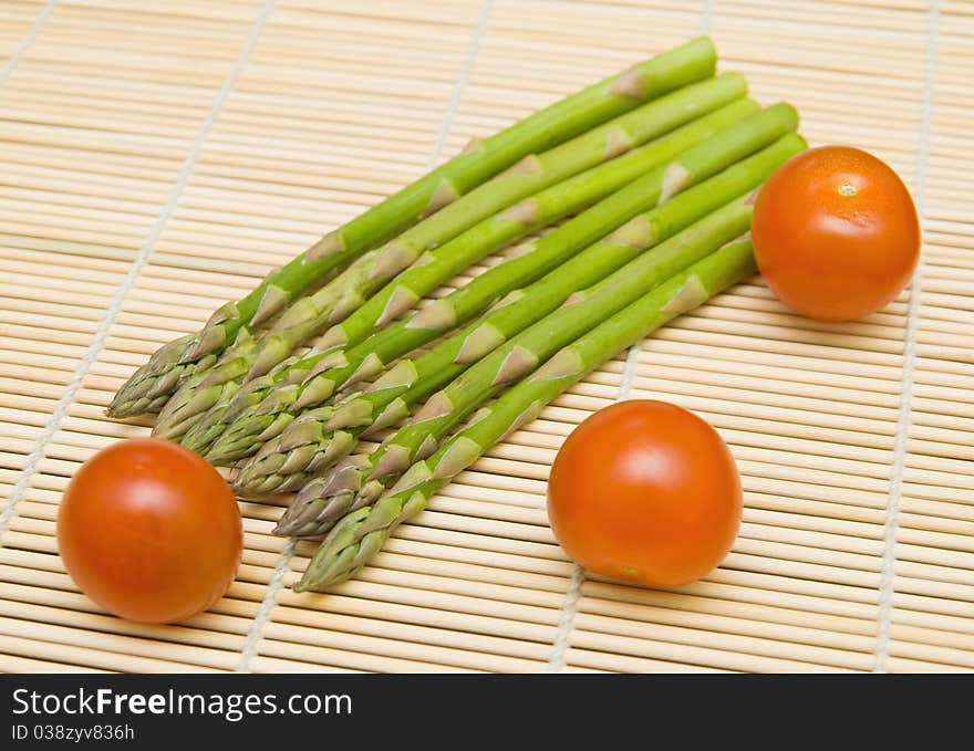 Asparagus and tamatos on bamboo substrate