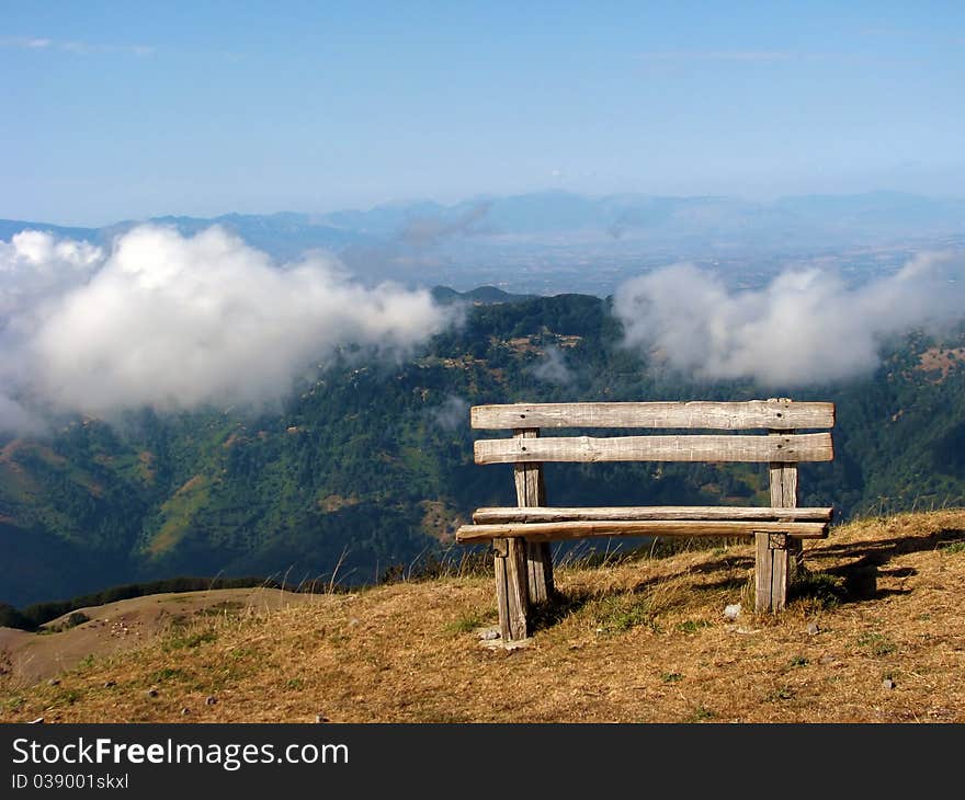 A bench in the mountains above the clouds. A bench in the mountains above the clouds