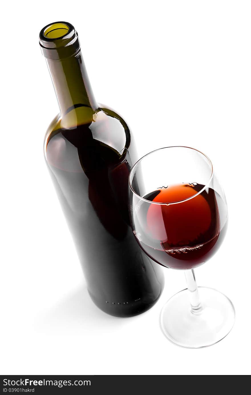 Glass and bottle with red wine on white