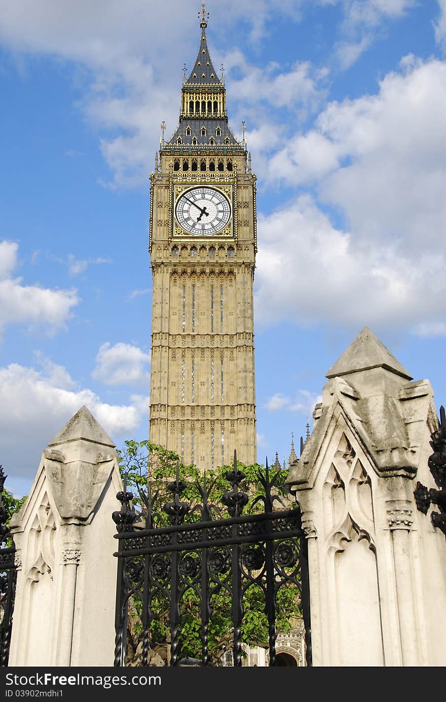 Big Ben clock tower in London stands behind decorative pillars and iron railings. Big Ben clock tower in London stands behind decorative pillars and iron railings.