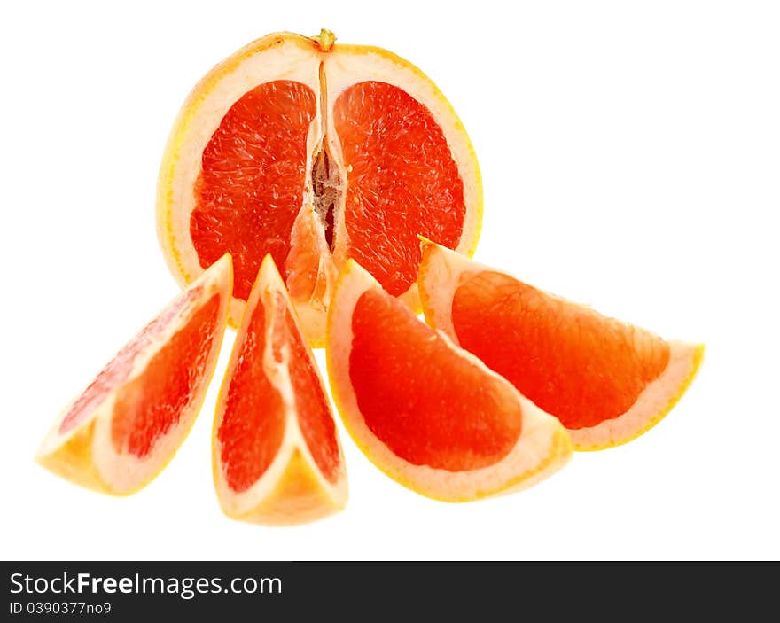 Half of grapefruit with four slices. Intentional shallow depth of field. Isolated on white background.