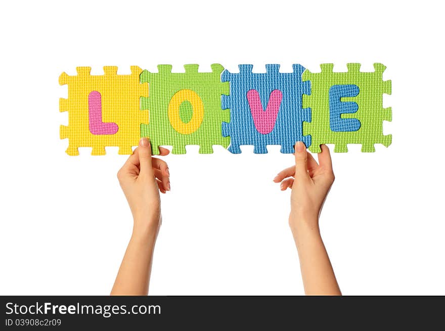 Teacher holding in the hand the amusing colored educational puzzles with the word love