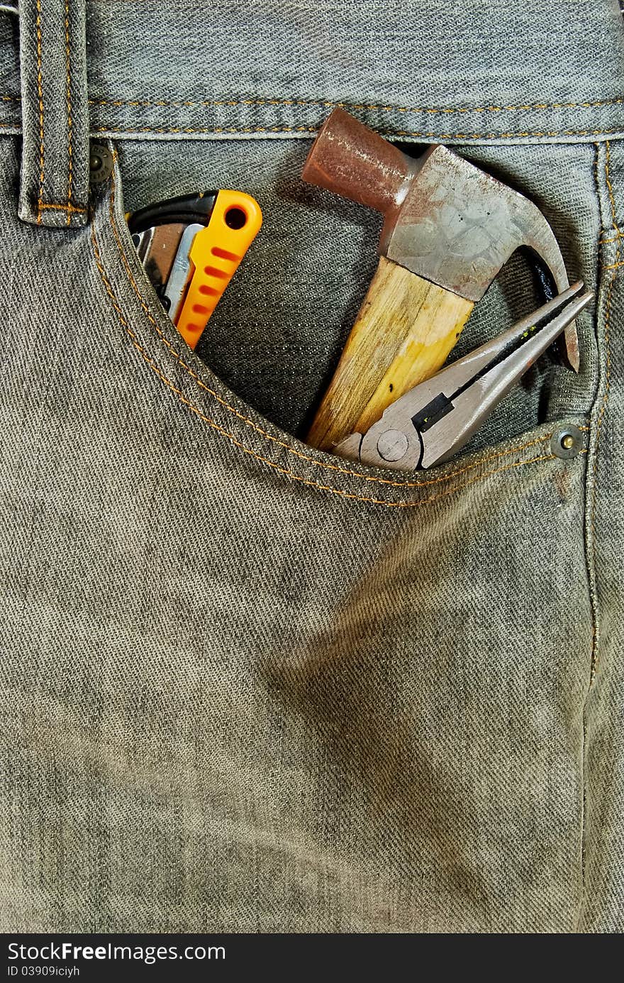 Repairman jean with tool in the pocket closeup background. Repairman jean with tool in the pocket closeup background