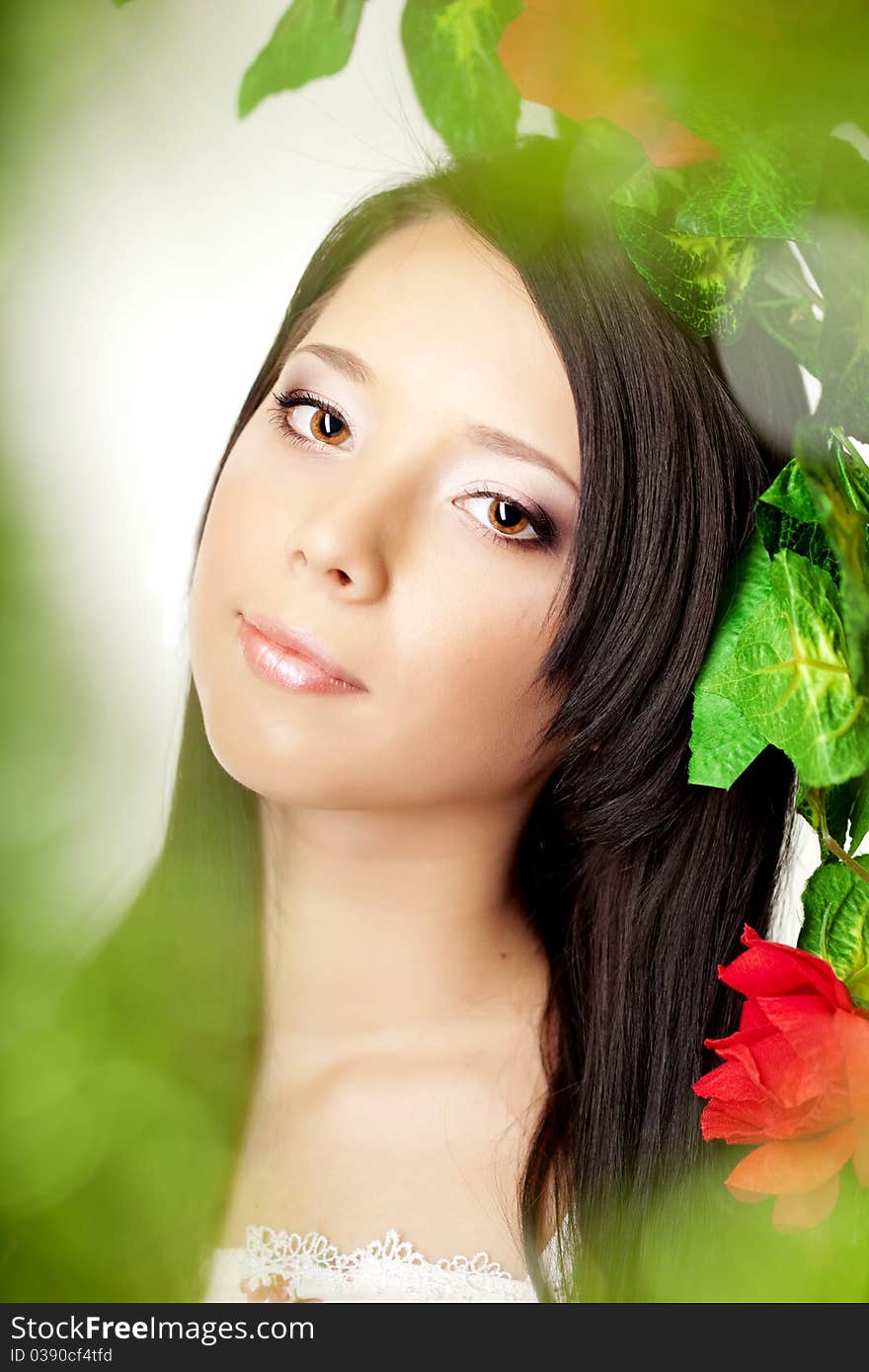 Beautiful girl with bright make-up among the roses