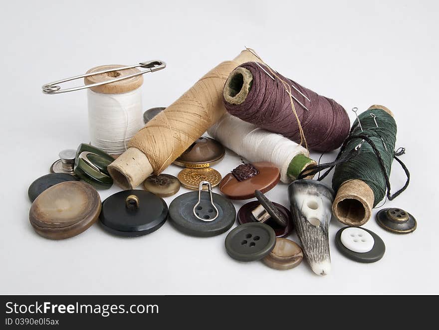 Thread and needles, buttons and pins on a white background