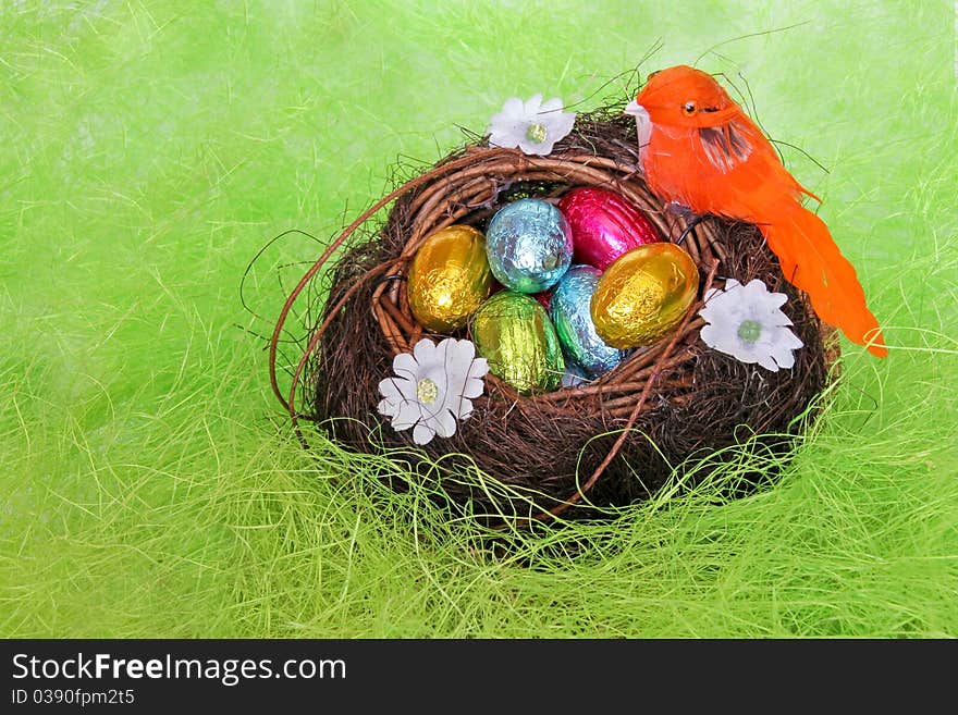 Chocolate eggs in the nest on the imitation of hay