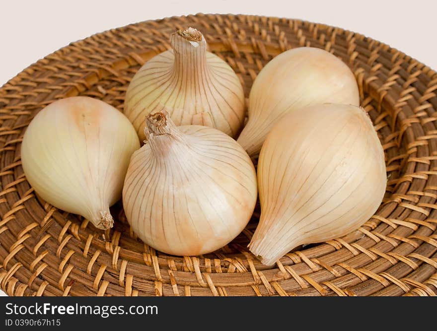 Ripe onions on a wicker plate