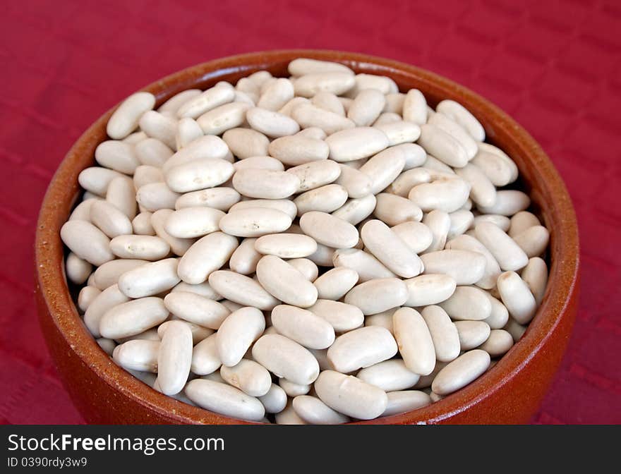 Raw white beans in ceramic bowl