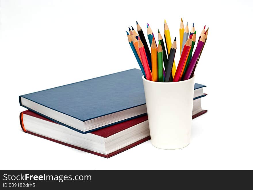 A stack of color books and pencils on the white background