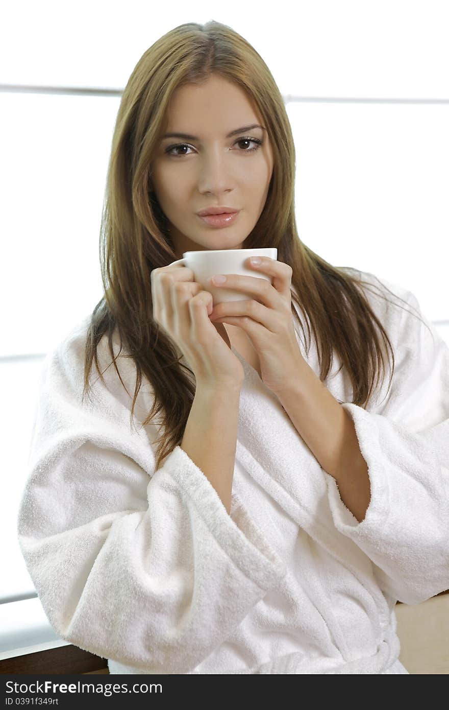 Attractive young woman in PJ's with her morning coffee