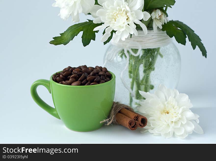 Coffee beans in a green cup on a white background