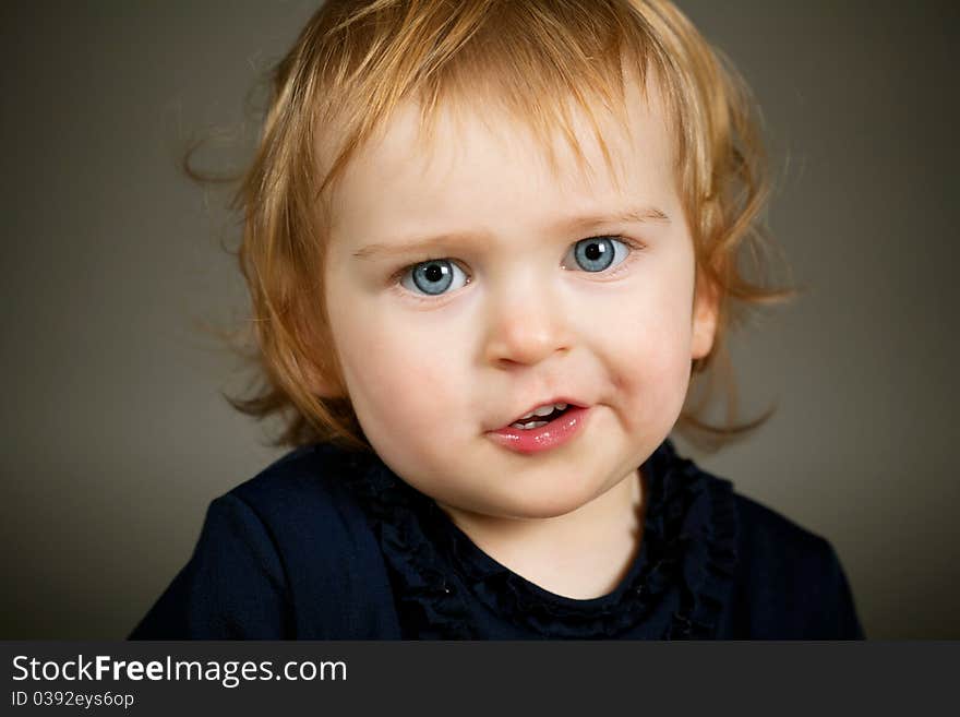 A little funny girl portrait on dark background