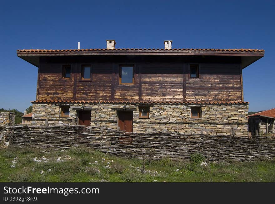 Traditional wooden house in a rural village of Bulgaria. This house house built in the old traditional way of stone and wood. Traditional wooden house in a rural village of Bulgaria. This house house built in the old traditional way of stone and wood