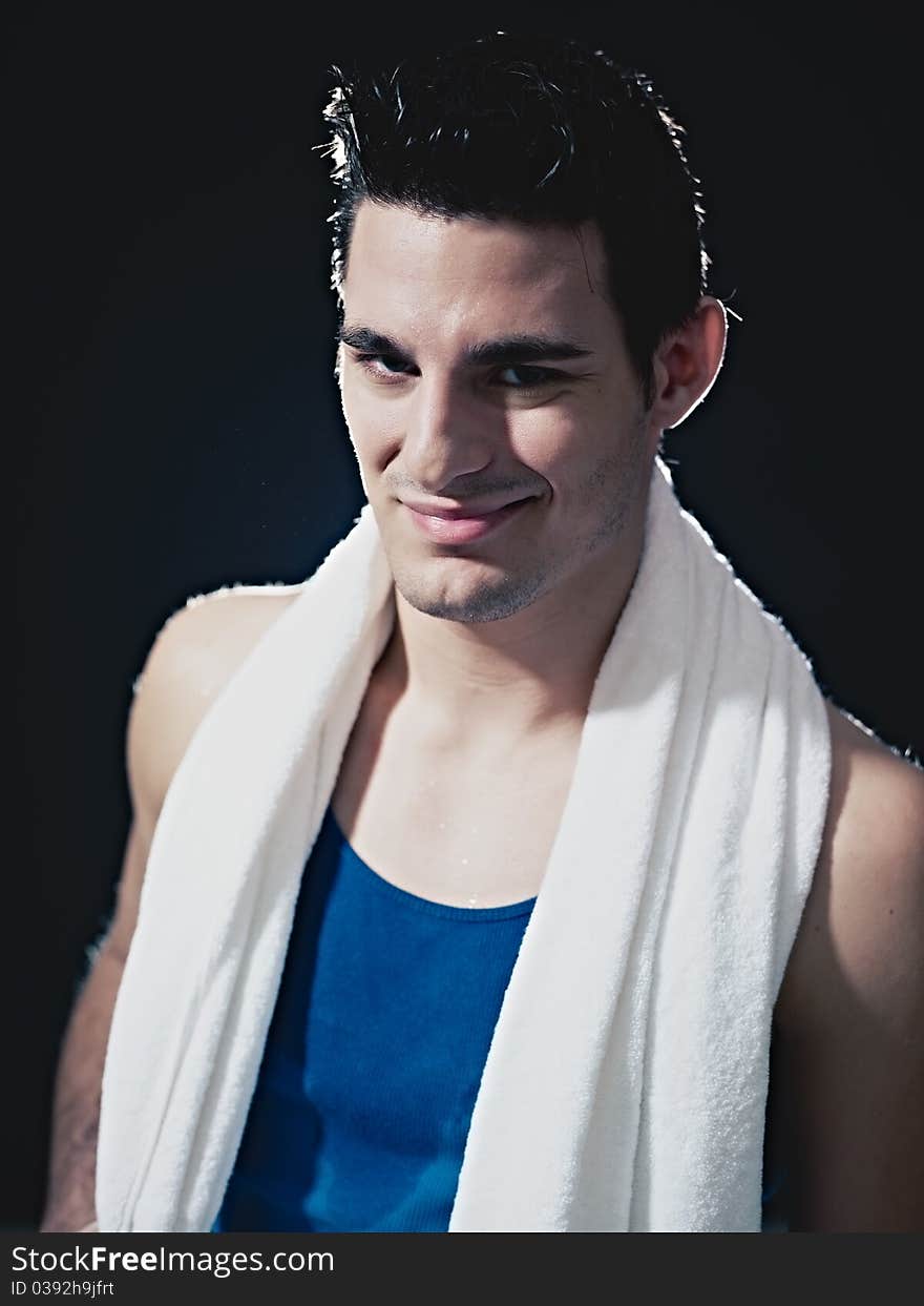 Portrait of confident caucasian male in sportswear, looking at camera and smiling on black background. Vertical shape, waist up, front view. Portrait of confident caucasian male in sportswear, looking at camera and smiling on black background. Vertical shape, waist up, front view