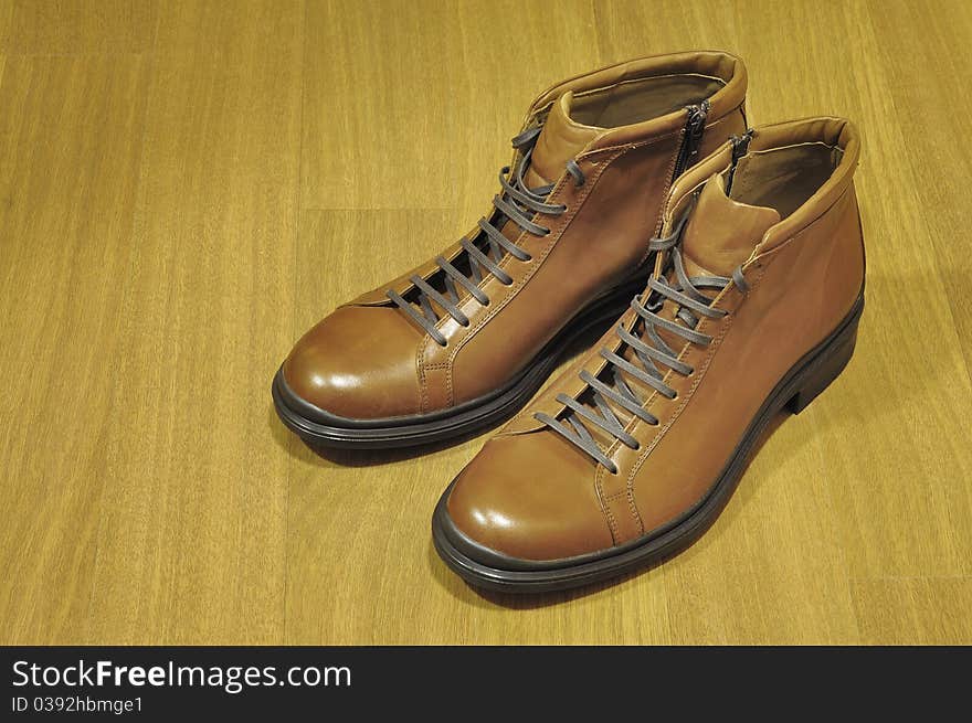 New brown boots on a wooden background. New brown boots on a wooden background