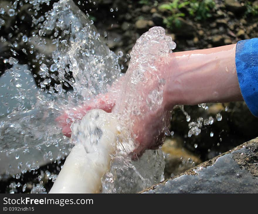 Closeup view of mountain spring water on the hand. Closeup view of mountain spring water on the hand