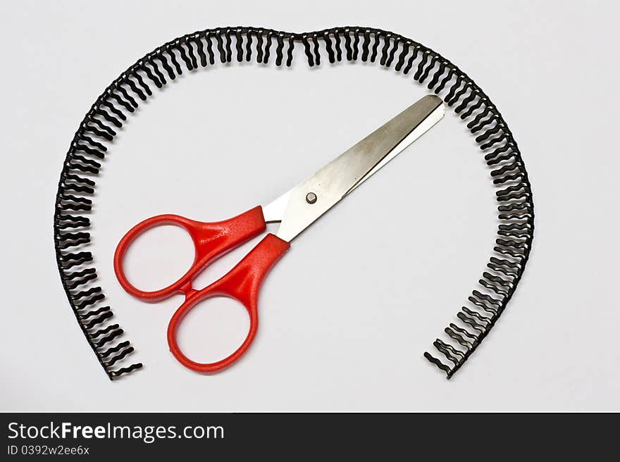 Scissors handle red background with a black headdress covering is placed. Scissors handle red background with a black headdress covering is placed