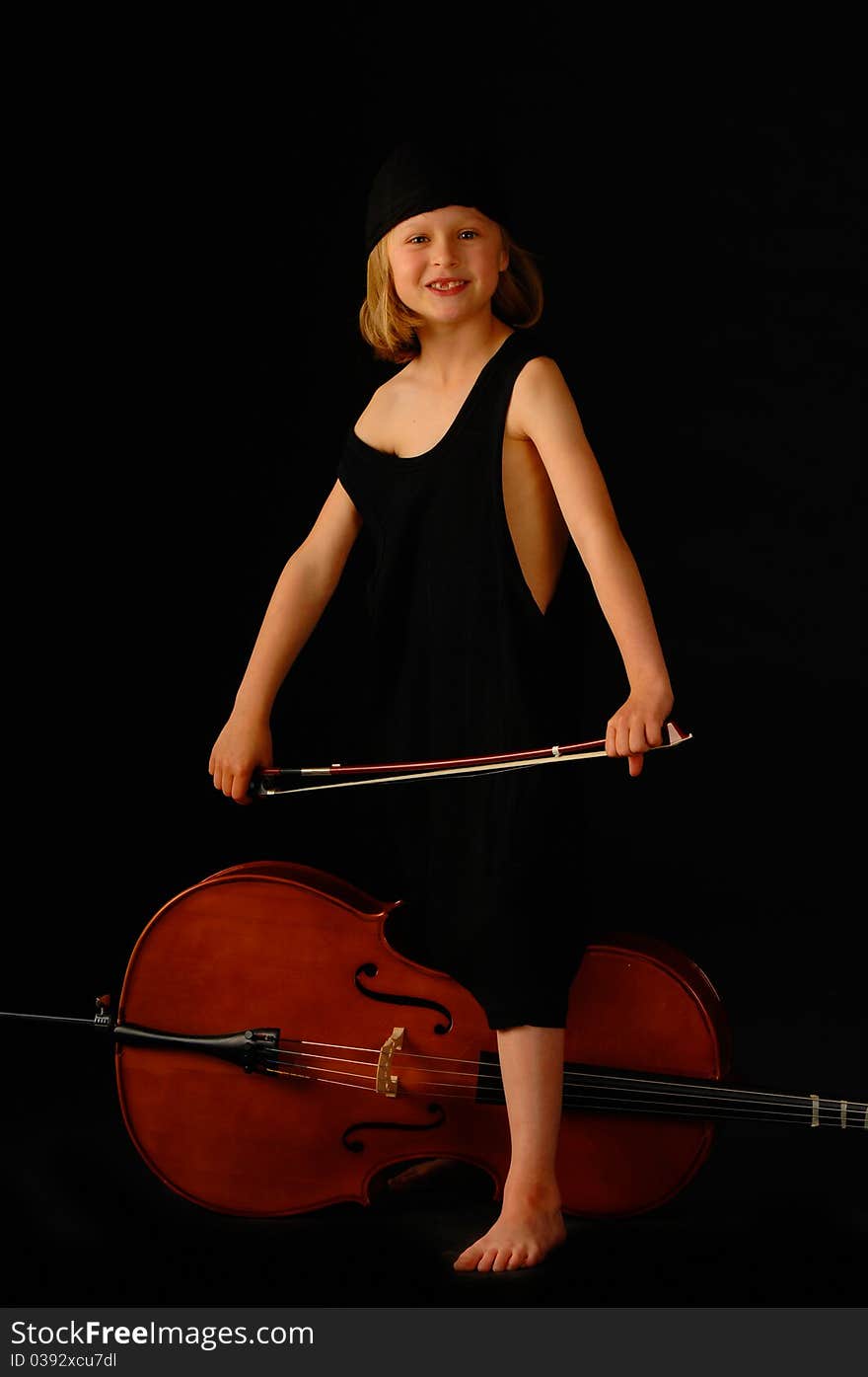 School aged girl with cello on black background. School aged girl with cello on black background