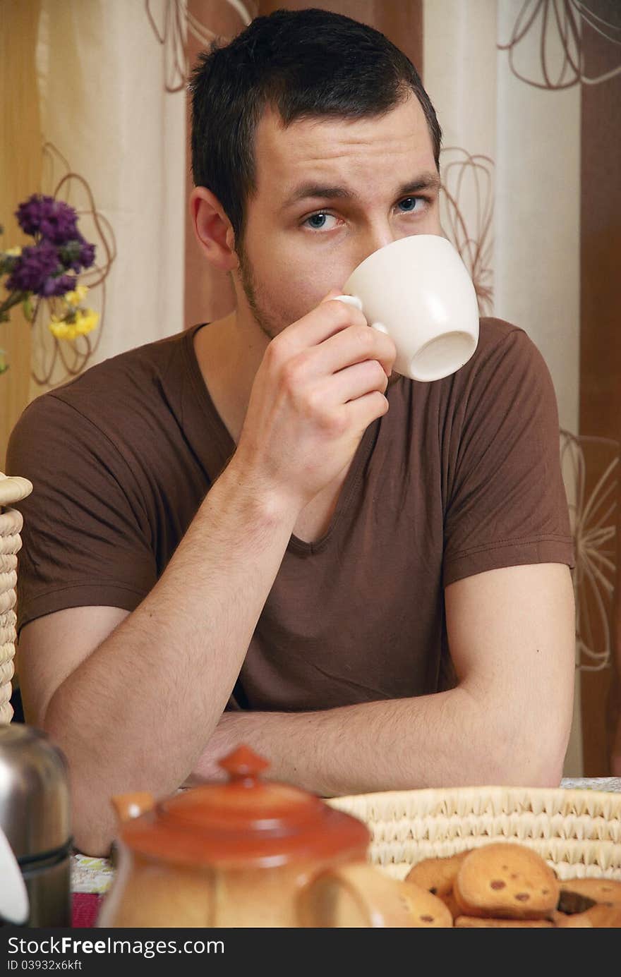 Young Guy With Tea And Rusk In The Kitchen