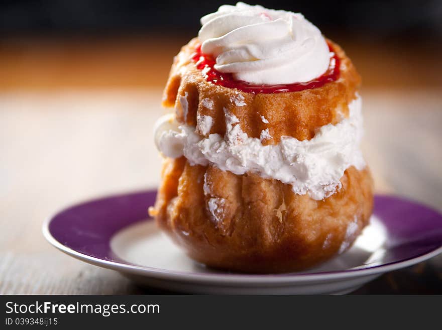 Cream puff drizzled with whipped cream. Cream puff drizzled with whipped cream