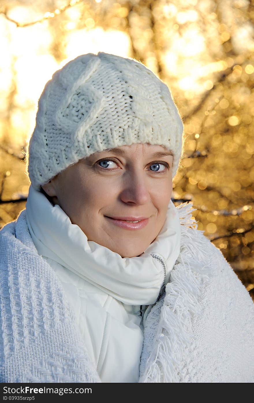 Blue-eyed woman in white in the winter forest. closeup, portrait