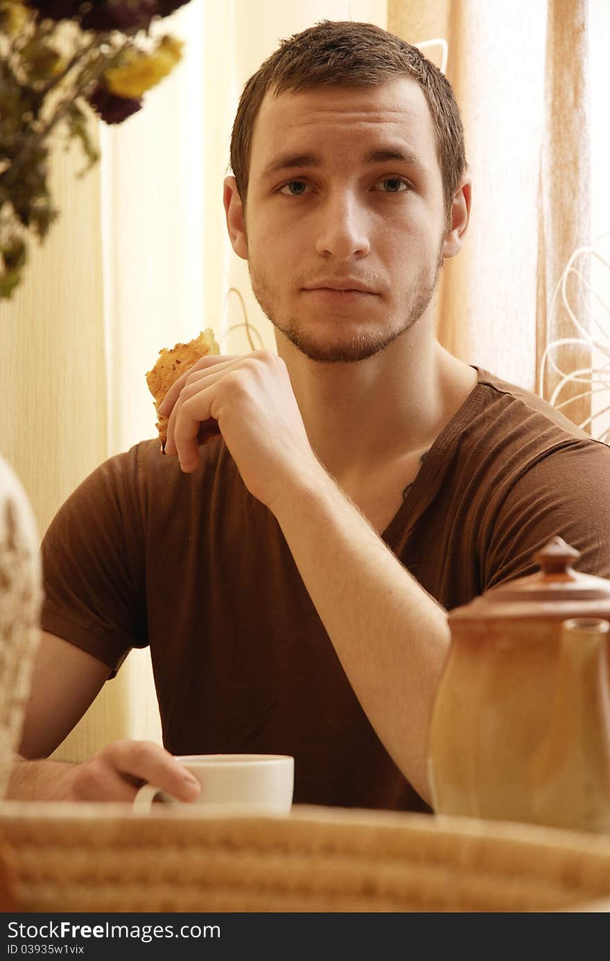 A young guy having a breakfast in the kitchen. A young guy having a breakfast in the kitchen