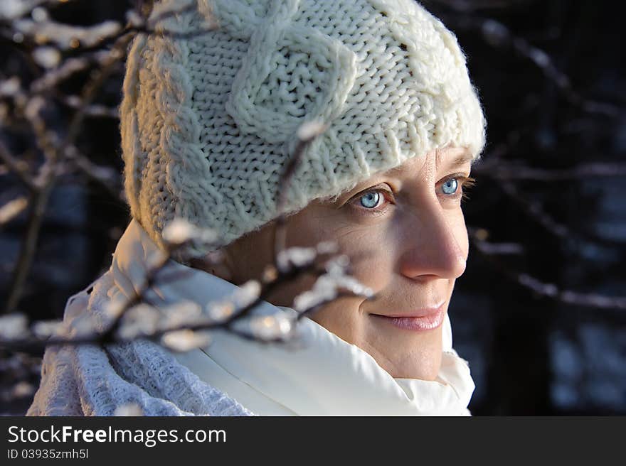 Blue-eyed woman in white in the winter forest. closeup, portrait