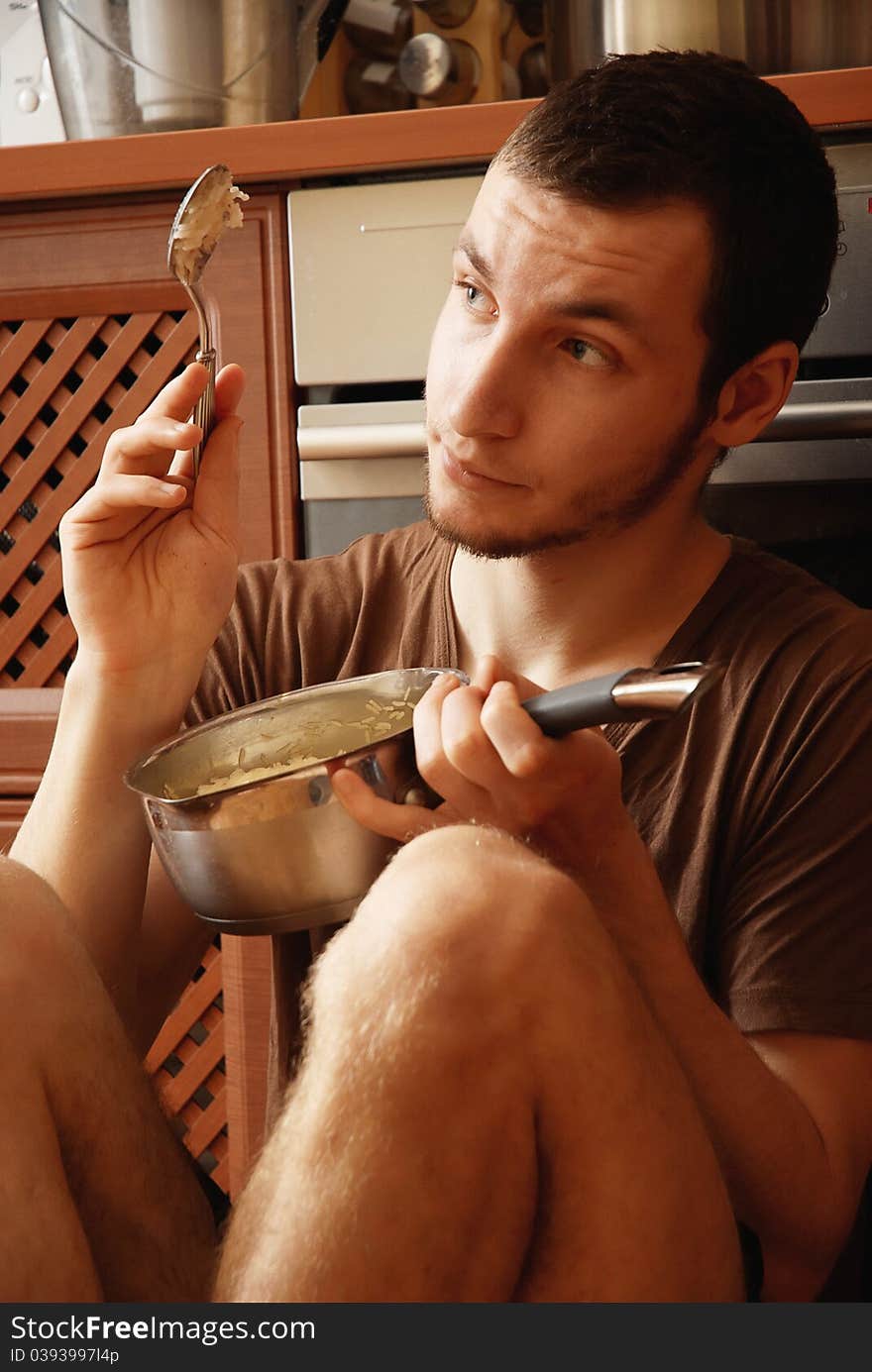 Guy with pot of rice in the kitchen