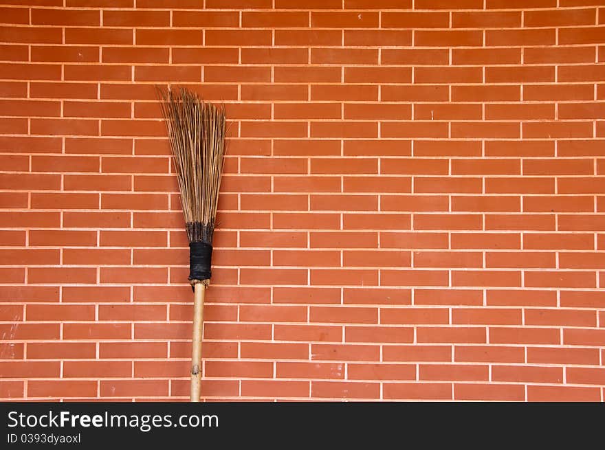 Broom on red brick wall. Broom on red brick wall