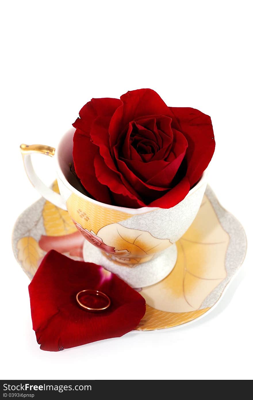 Red rose in a cup of coffee and a saucer with a petal ring. Red rose in a cup of coffee and a saucer with a petal ring