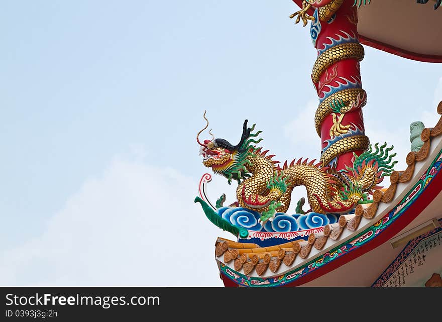 Dragon sculpture on roof of chinese shrine and the blue sky,East of Thailand