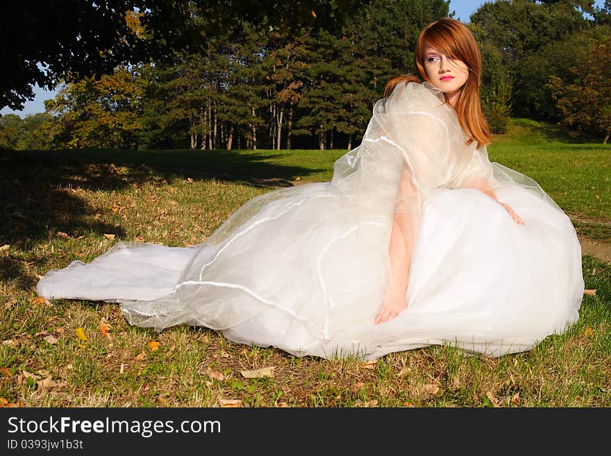 Young beautiful woman posing in a white dress in the nature. Young beautiful woman posing in a white dress in the nature