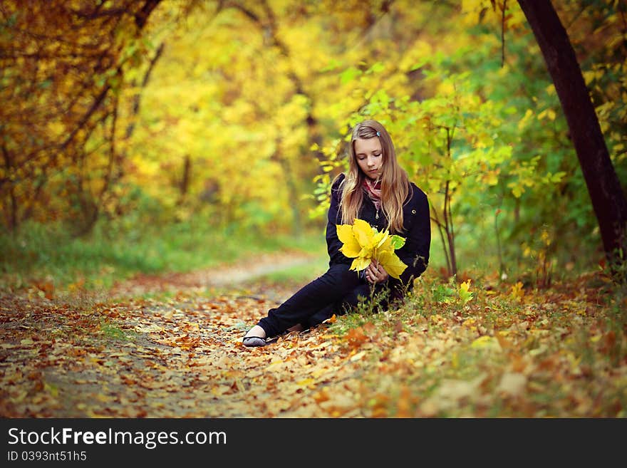 A beautiful girl goes for a walk in an autumn park. A beautiful girl goes for a walk in an autumn park