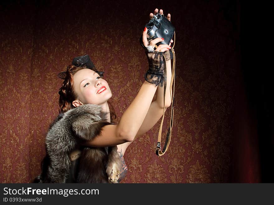 Young vintage woman with camera in old-style studio. Young vintage woman with camera in old-style studio