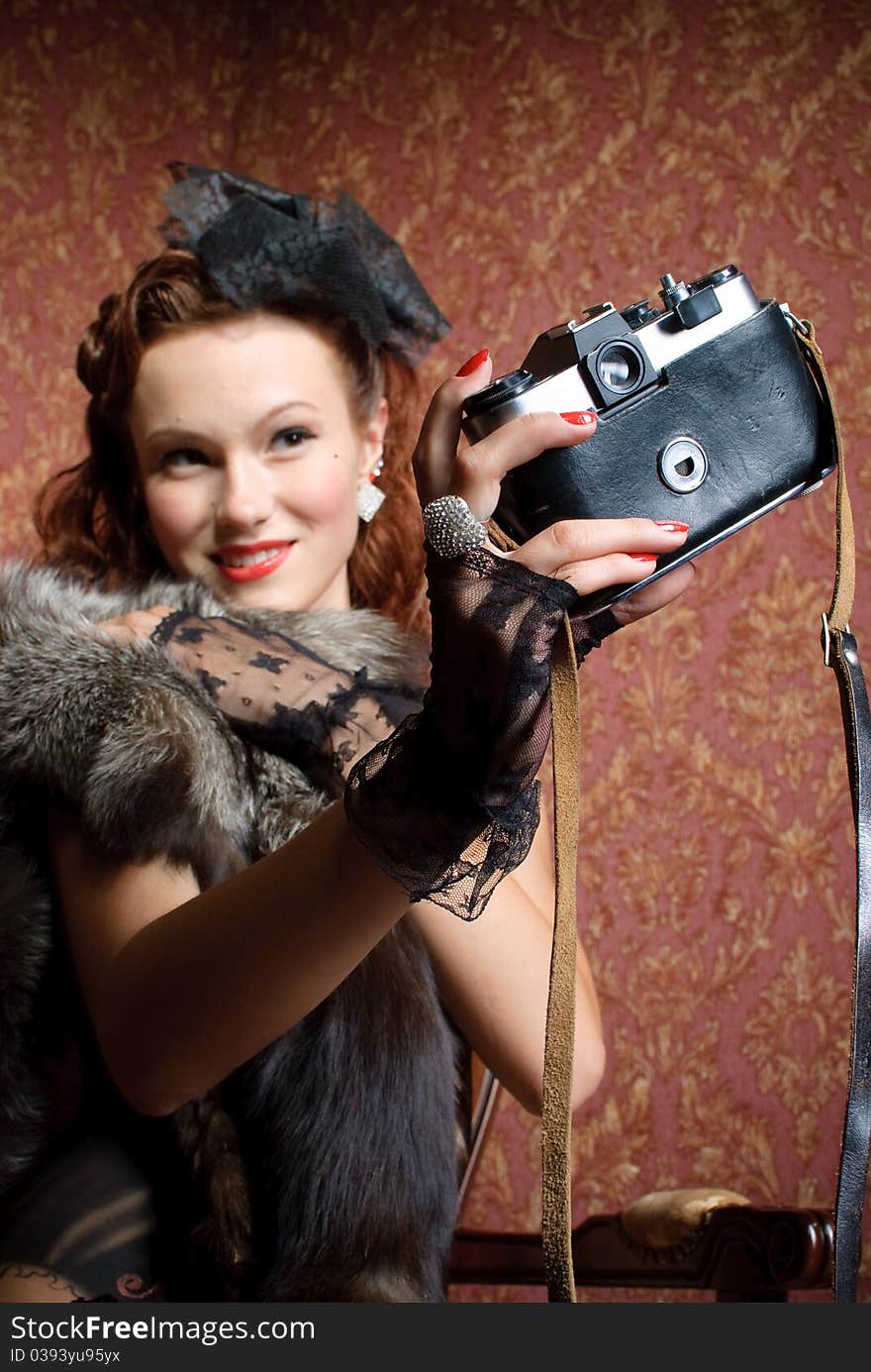 Young vintage woman with camera in old-style studio. Young vintage woman with camera in old-style studio