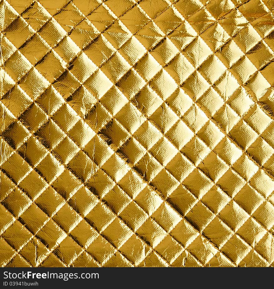 A piece of material with golden square texture. A piece of material with golden square texture