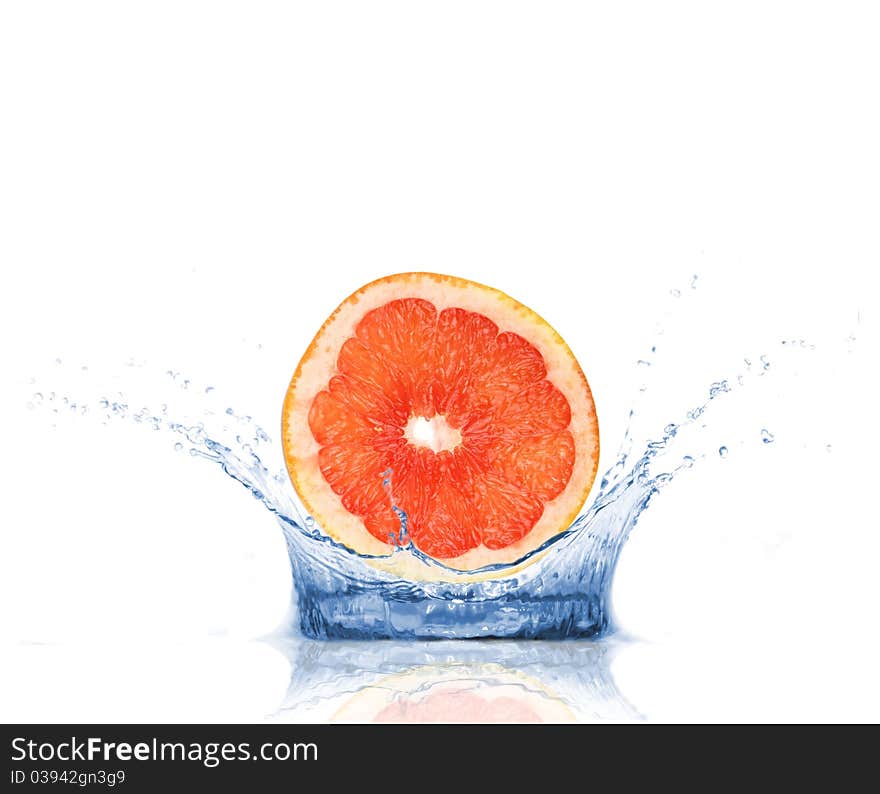 SLice of grapefruit falling into water, isolated on white background. SLice of grapefruit falling into water, isolated on white background