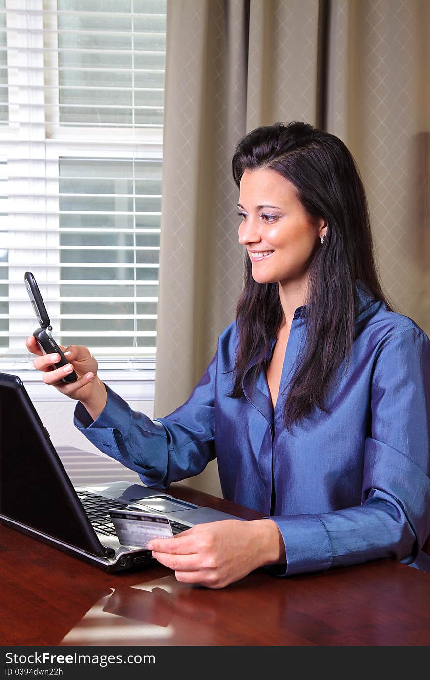 Woman using credit card, cell phone and computer. Woman using credit card, cell phone and computer