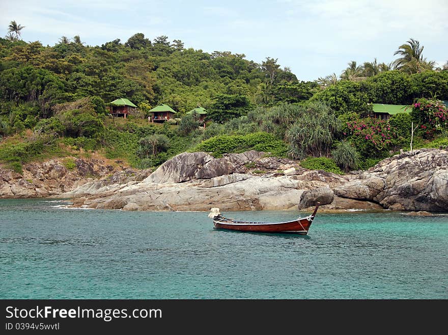 Longtail boat near island, in blue water. Longtail boat near island, in blue water