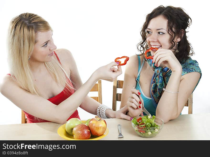 Girlfriends cheerfully feed each other with healthy food