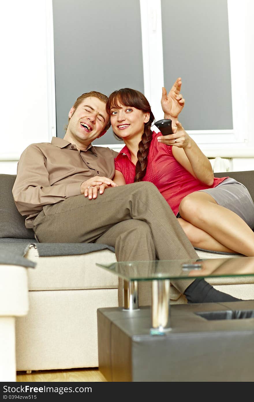 Nice couple watching tv at home and laughing