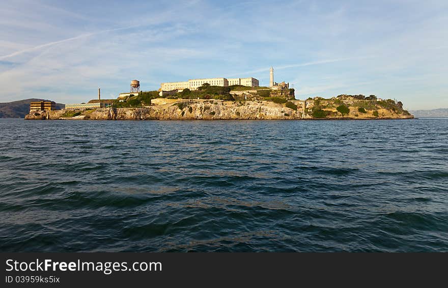 Wide angle panorama of Alcatraz Island and prison in warm afternoon light.