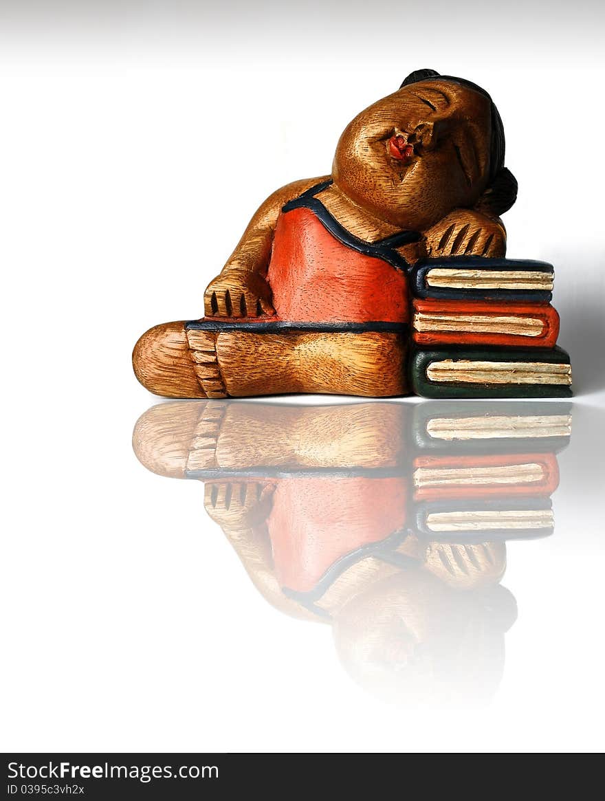 Photo of an Asian themed handcarved and painted wood carving against a white background with reflection. Photo of an Asian themed handcarved and painted wood carving against a white background with reflection