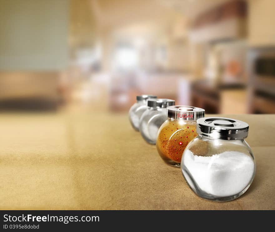 Shallow depth of field photo of a series of spice jars in modern kitchen with focus on a decorative brown sugar container