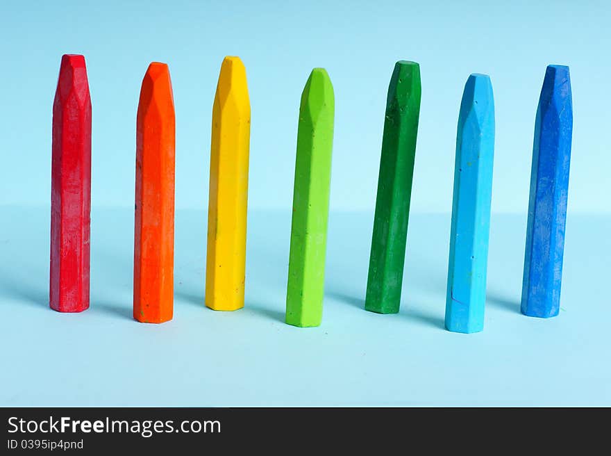 Colorful crayons on the blue background