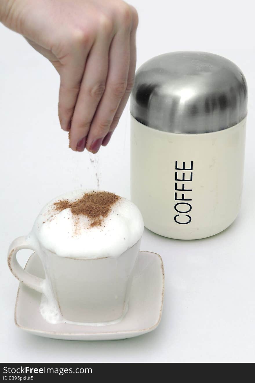 Sprinkle coffe with chocolate and coffee can.