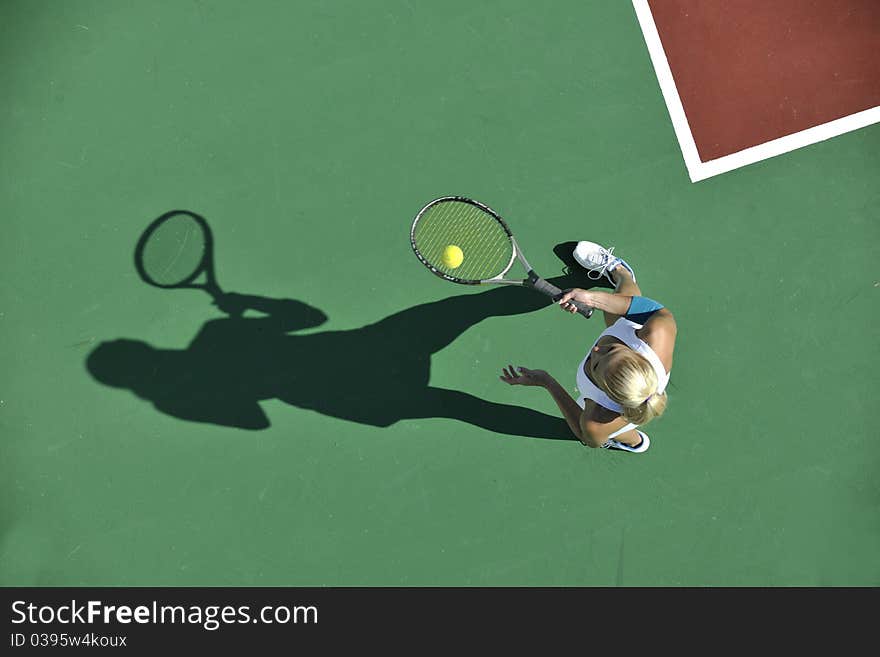 Young fit woman play tennis outdoor on orange tennis field at early morning. Young fit woman play tennis outdoor on orange tennis field at early morning